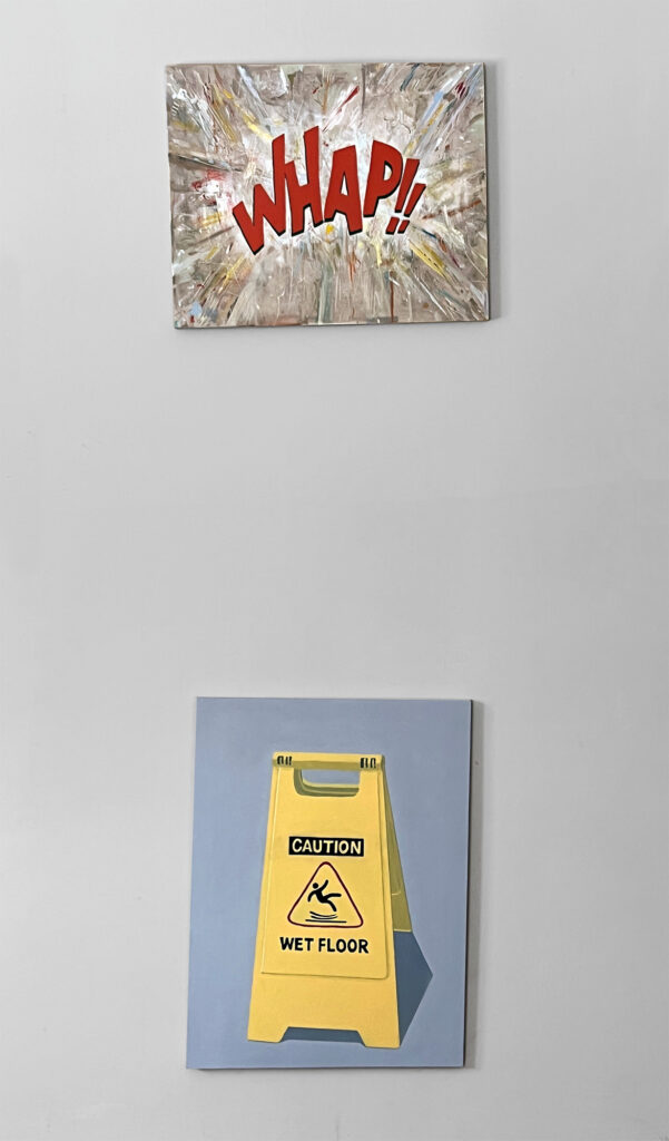 A pair of paintings on a wall.  A 16" x 20" painting at eye level. The second painting is 18" x 24" and located directly behind the other painting close to the floor. The top painting has a beige background covered in splatter paint with whites and hits of grays, reds, blues, and yellows.  In the center is the red text that reads:WHAM!!" The second painting is a hard edge painting of a yellow folding sign that reads "CAUTION Wet Floor" with a red triangle that has a back fallowing figure silhouette falling. 